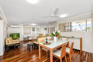a dining room and living room with a table and chairs at Townsville Accommodation in Low-Maintenance Living in Aitkenvale