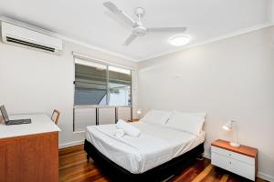 a white bedroom with a bed and a window at Townsville Accommodation in Low-Maintenance Living in Aitkenvale