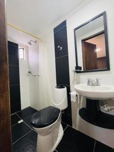 a bathroom with a black and white toilet and a sink at Acogedora casa en el carmen de Viboral in Carmen de Viboral