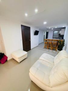 a living room with a white couch and a table at Acogedora casa en el carmen de Viboral in Carmen de Viboral