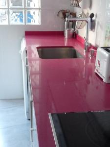 a kitchen with a red counter top with a sink at Apartment Savoy in Valencia