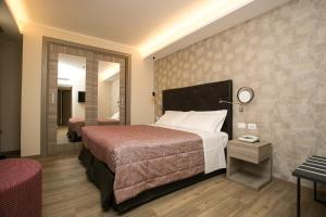 Habitación de hotel con cama grande y espejo en Hotel Abano Verdi en Abano Terme