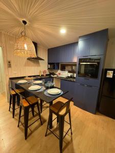 巴拉斯港Loft Río Maullín, naturaleza y descanso de la mano con la modernidad的厨房配有黑色桌椅和冰箱。 更多20张照片