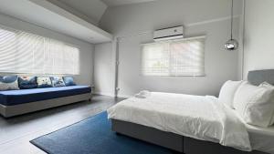 a bedroom with a bed and a blue couch at Little Escape in Bangkok