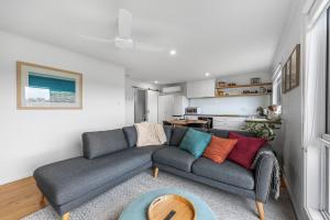 ein Wohnzimmer mit einer grauen Couch und einem Tisch in der Unterkunft The Bungalow in Warrnambool