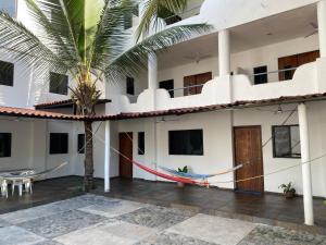 a building with a hammock in the courtyard at Costa Ayala - Bungalow 1 with 2 dbl beds and 2 sofas in Los Ayala