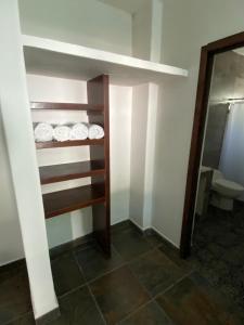 ein Badezimmer mit Toilette und einem Regal mit Tellern in der Unterkunft Costa Ayala - Bungalow 1 with 2 dbl beds and 2 sofas in Los Ayala