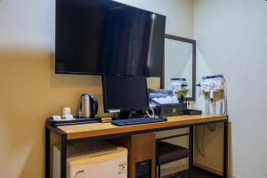 a desk with a computer monitor and a keyboard at Yeosu Hi Motel in Yeosu