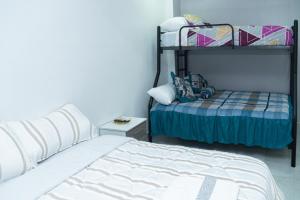 une chambre avec un lit et un lit superposé dans l'établissement Deramai, à Santo Domingo de los Colorados