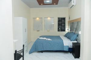 une chambre avec un lit avec des draps bleus et blancs dans l'établissement Deramai, à Santo Domingo de los Colorados