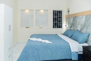 une chambre avec un lit bleu et blanc et une fenêtre dans l'établissement Deramai, à Santo Domingo de los Colorados