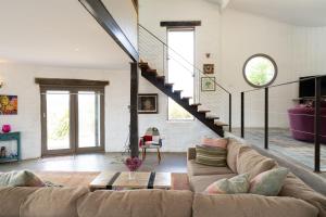 a living room with a couch and a staircase at Lithia Guest House - Daylesford Region in Hepburn Springs