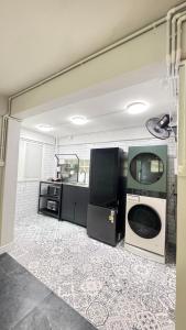 a laundry room with a washing machine and a tv at Little Escape in Bangkok +9 photos