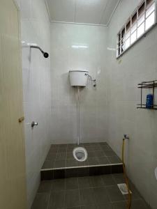 a bathroom with a toilet in the floor of a stall at Homestay Anjung Desa in Kuantan