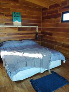 ein Schlafzimmer mit einem Bett in einer Blockhütte in der Unterkunft Casas de Mar Cielo Azul in Badeort Reta