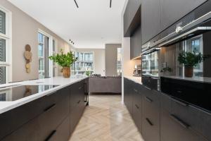 a large kitchen with black cabinets and white counters at Unbeatable Central Location - Reykjavíks Most Exclusive Luxury Apartments in Reykjavík