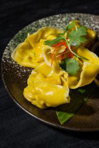 a plate of food with pasta on a table at Je Ne Sais Quoi Seminyak in Seminyak
