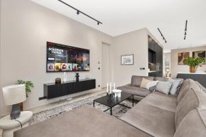 a living room with a couch and a tv at Unbeatable Central Location - Reykjavíks Most Exclusive Luxury Apartments in Reykjavík