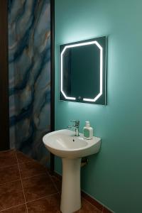 a bathroom with a sink and a mirror at Ethlyn House in Bocas del Toro