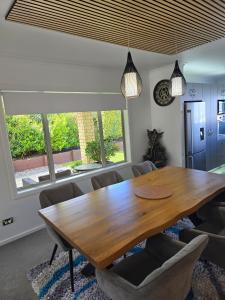 a dining room with a wooden table and chairs at Enjoy 4br home with lots of comfort & convenience in Taupo