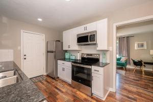 泰勒The Vintage Vibe - A Brickstreet Oasis的厨房配有白色橱柜和黑色灶台烤箱。 更多7张照片