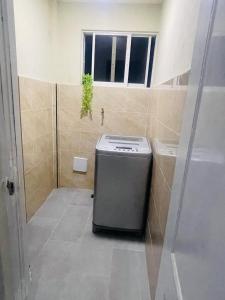 a small refrigerator in a bathroom with a window at Apartamento cerca del aeropuerto en los frailes in Los Frailes