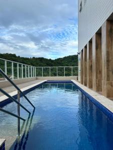 Apartamento Canto do Forte في برايا جراندي: مسبح على جانب مبنى +7 صور