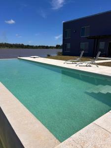 a swimming pool with two chairs and a building at La moradaa in Federación