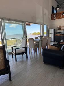 a living room with a table and chairs and the ocean at La moradaa in Federación