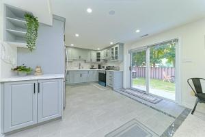 a kitchen with white cabinets and a large window at SPACIOUS FULLY PRIVATE 2BR UNIT ON GROUND Private 2BR LEVEL in Burlington