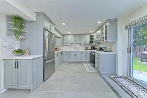 a large kitchen with white cabinets and a large window at SPACIOUS FULLY PRIVATE 2BR UNIT ON GROUND Private 2BR LEVEL in Burlington +12 photos