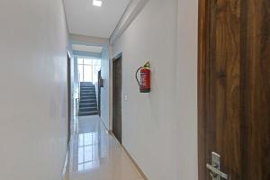 einen Flur mit einem Feuerlöscher an der Wand in der Unterkunft Hotel O Safari Inn in Hāpur