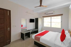 ein Schlafzimmer mit Bett, Schreibtisch und Fenster in der Unterkunft Hotel O Safari Inn in Hāpur