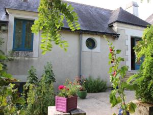 a house with a garden with flowers in the yard at Gîte Ferme Traditionnelle Près de la Forêt, Animaux Admis - FR-1-381-68 in Cheillé
