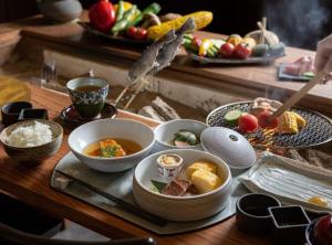 a table with bowls of food and plates of food at Nazuna Kyoto Higashi Honganji in Kyoto