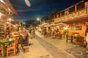 um grupo de pessoas andando por uma rua à noite em M a r e a V i v a -Bonita y tranquila casa familiar con hospedaje- em Zipolite