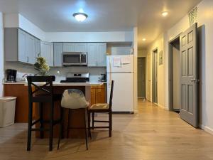 a kitchen with a white refrigerator and two chairs at A sweet home-Room D in Woodside