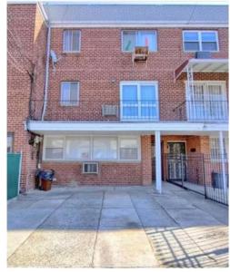 a brick apartment building with a large driveway at A sweet home-Room D in Woodside