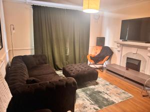 een woonkamer met een bank, een stoel en een open haard bij Cozy Nest in Grays Thurrock