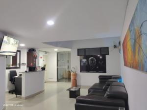 un salon avec des canapés et une table ainsi qu'une cuisine dans l'établissement Gran Hotel Coral, à Popayan