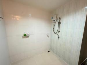 a bathroom with a shower with white tile walls at Aonang Mountain View A5 in Ao Nang Beach