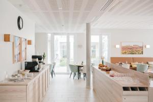 uma sala com mesas e cadeiras num edifício em Quality Suites Quiberon em Quiberon