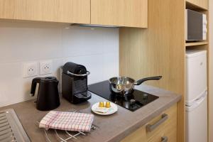 a kitchen with a counter with a pot on a stove at Zenitude Hôtel-Résidences Bordeaux Saint-Jean in Bordeaux