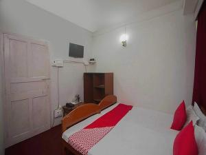 ein Schlafzimmer mit einem Bett mit roten Kissen in der Unterkunft Hotel O Home Heritage Homestay in Takdāh + 43 Fotos