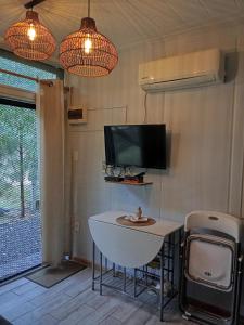 a room with a small table and a tv and a tv at Tu lugar de relax a 2 cuadras de la playa Se reserva con seña in Guazuvira