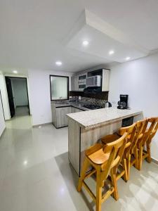 a kitchen with wooden chairs and a counter top at Acogedora casa en el carmen de Viboral in Carmen de Viboral