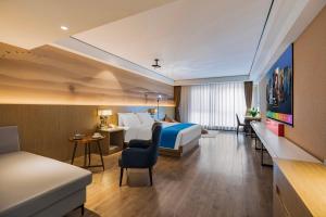 ein Hotelzimmer mit Bett und Schreibtisch in der Unterkunft Ramada Encore by Wyndham Kunming Guandu in Kunming