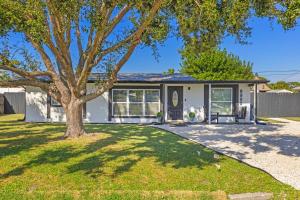 une maison avec un arbre dans la cour avant dans l'établissement Casa Tranquila Pool Pergola Spa Shower Retreat, à Venice