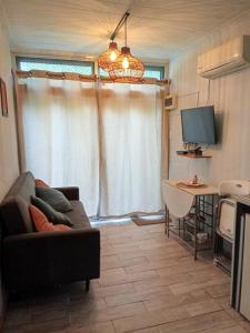 una sala de estar con un sofá y una mesa en Tu lugar de relax a 2 cuadras de la playa Se reserva con seña, en Guazuvirá