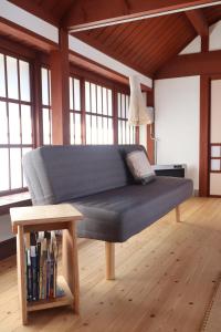 a bed in a room with a table and windows at Essai B&B - Quiet Village Retreat in Gokayama, near Shirakawa-go in Nanto